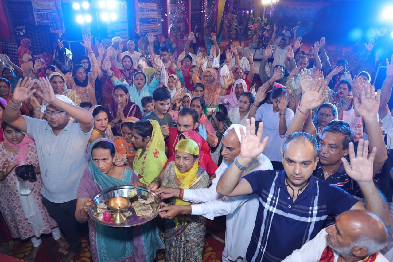 Devotees with raised hands during aarti