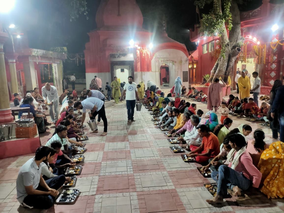 Devotees seated in rows in the courtyard at night