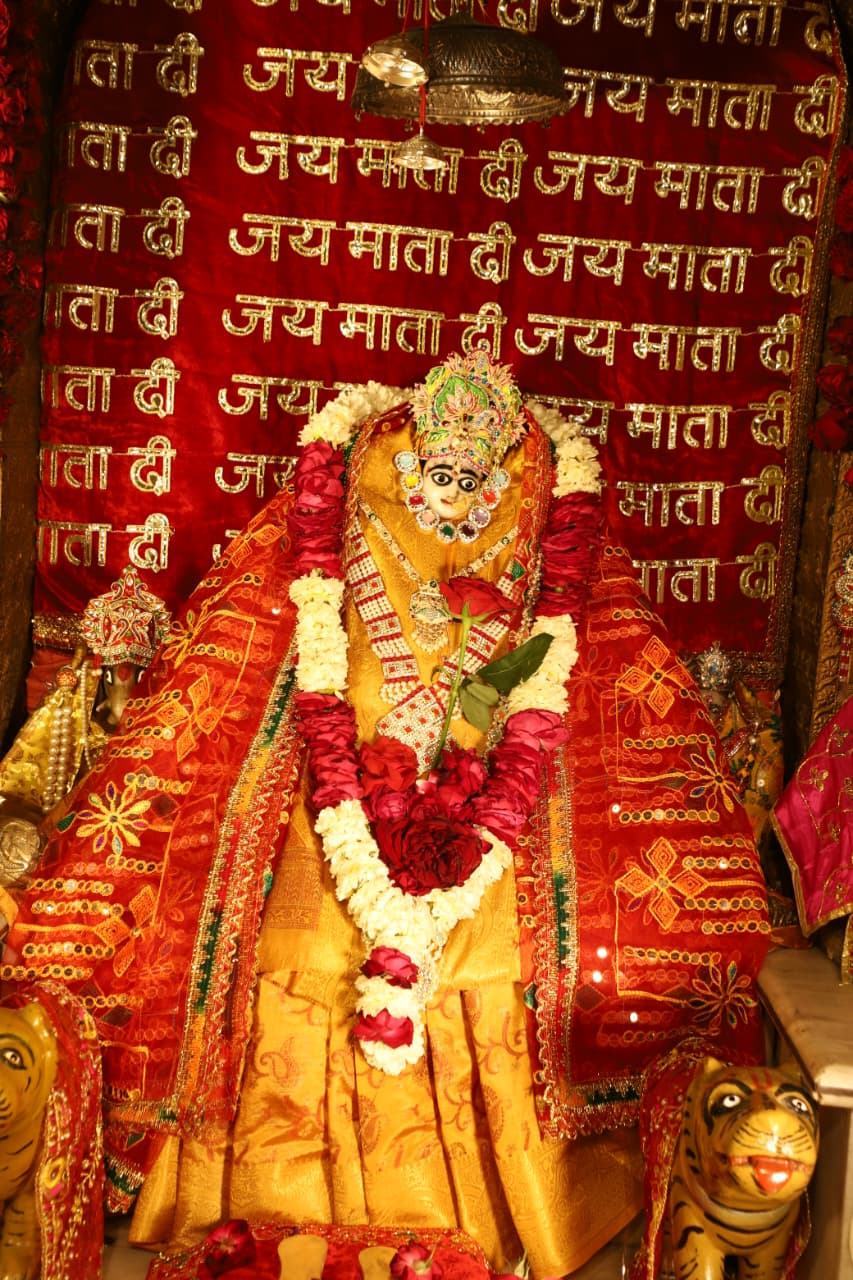 Maa Jayanti Devi before a wall inscribed with Jai Mata Di