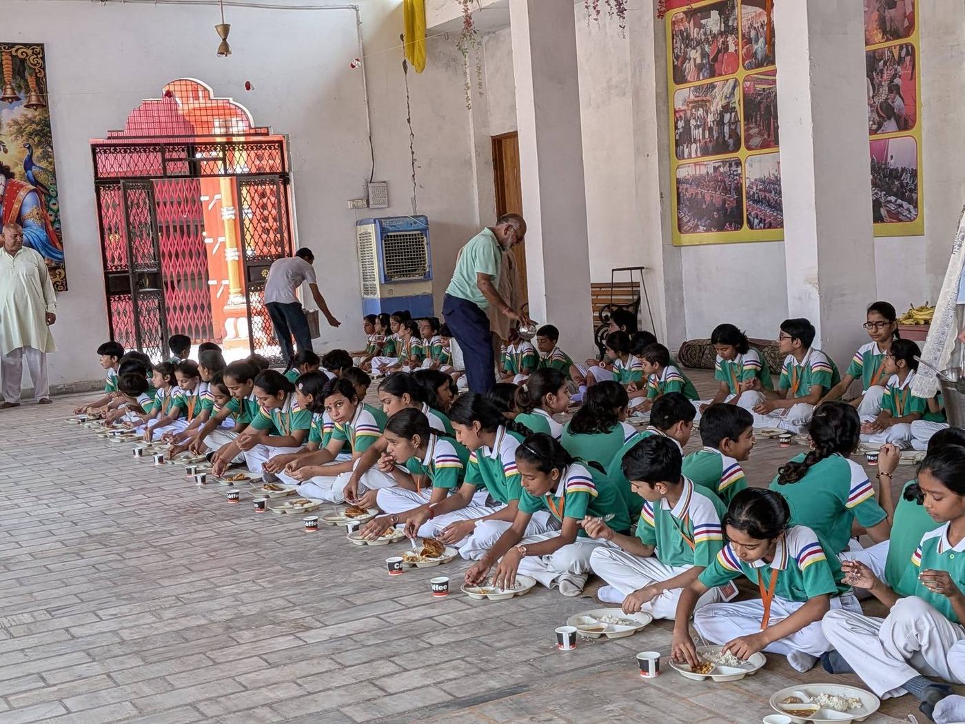 Girls seated in long rows for the Kanya Pujan inside the mandir hall